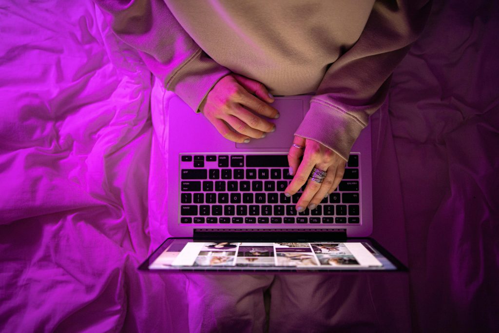 pexels-photo-5821037-5821037 Top view of unrecognizable person using laptop with neon purple lighting, creating a vibrant high-tech atmosphere.